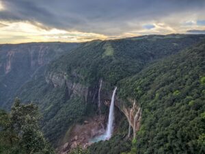 Waterfall cascading over a very tall cliff and falling into a pool.
